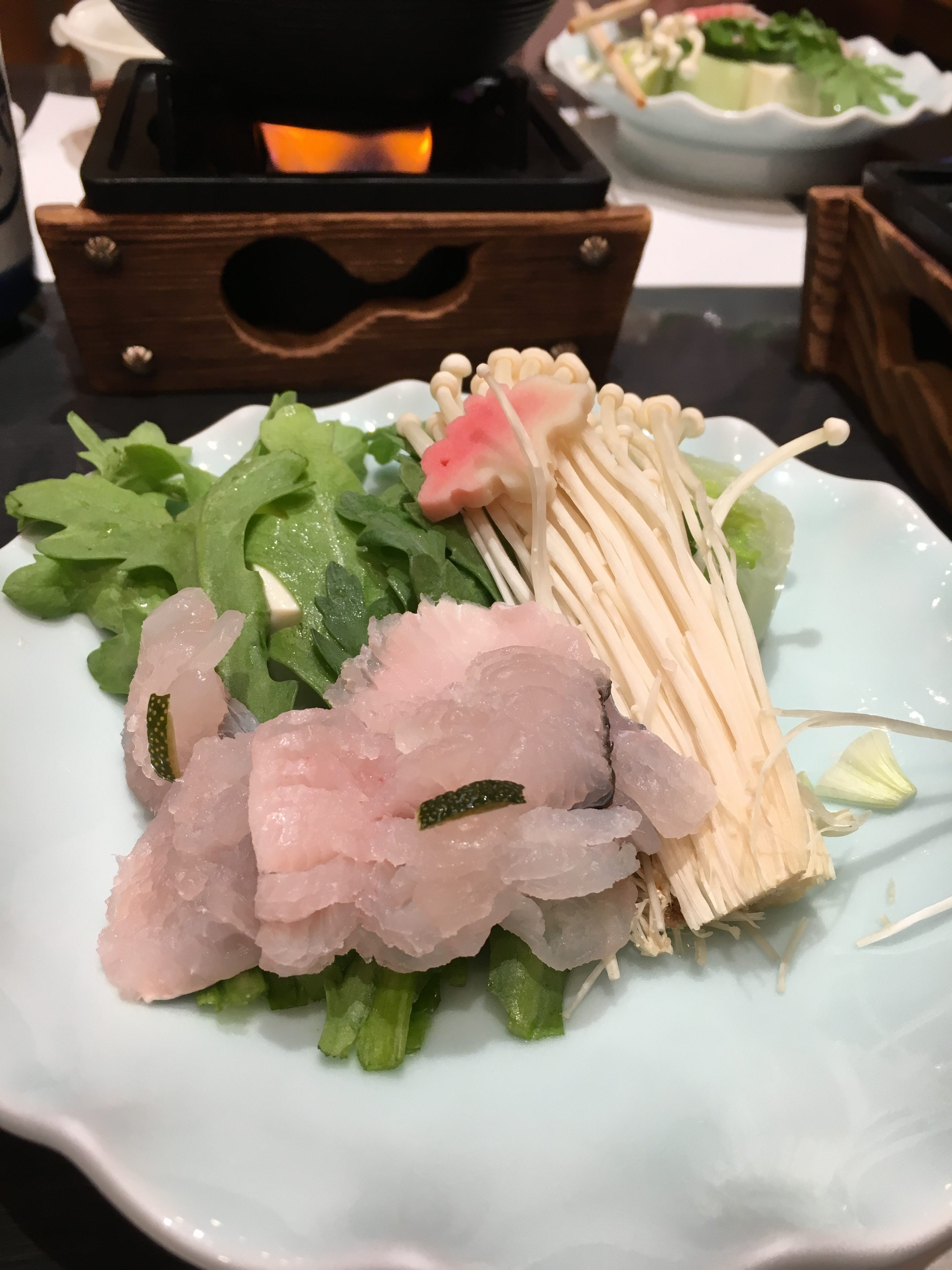 hamo sashimi on a bed of chrysanthemum leaves 