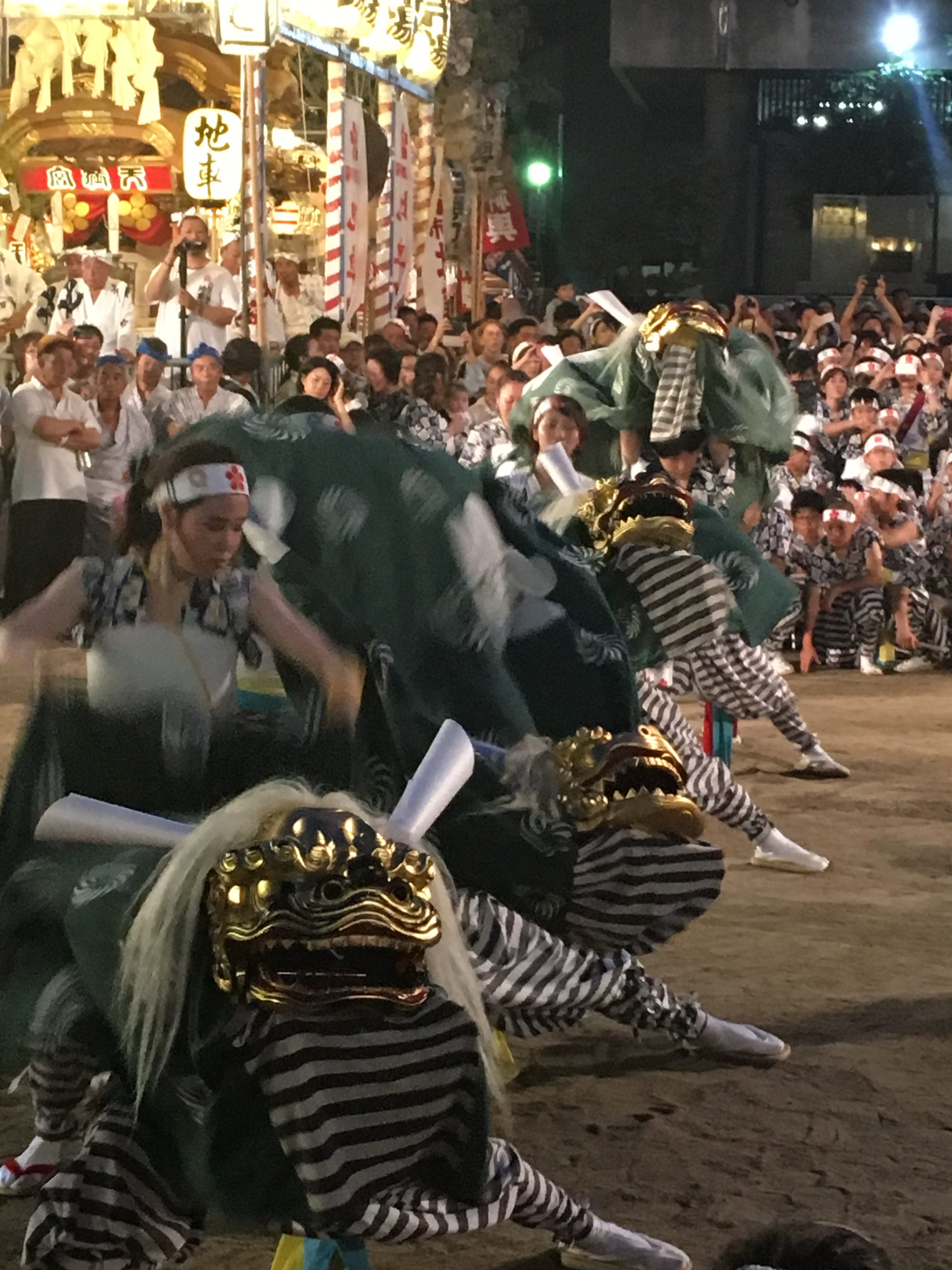 dancers in green and gold shishimai costumes performing