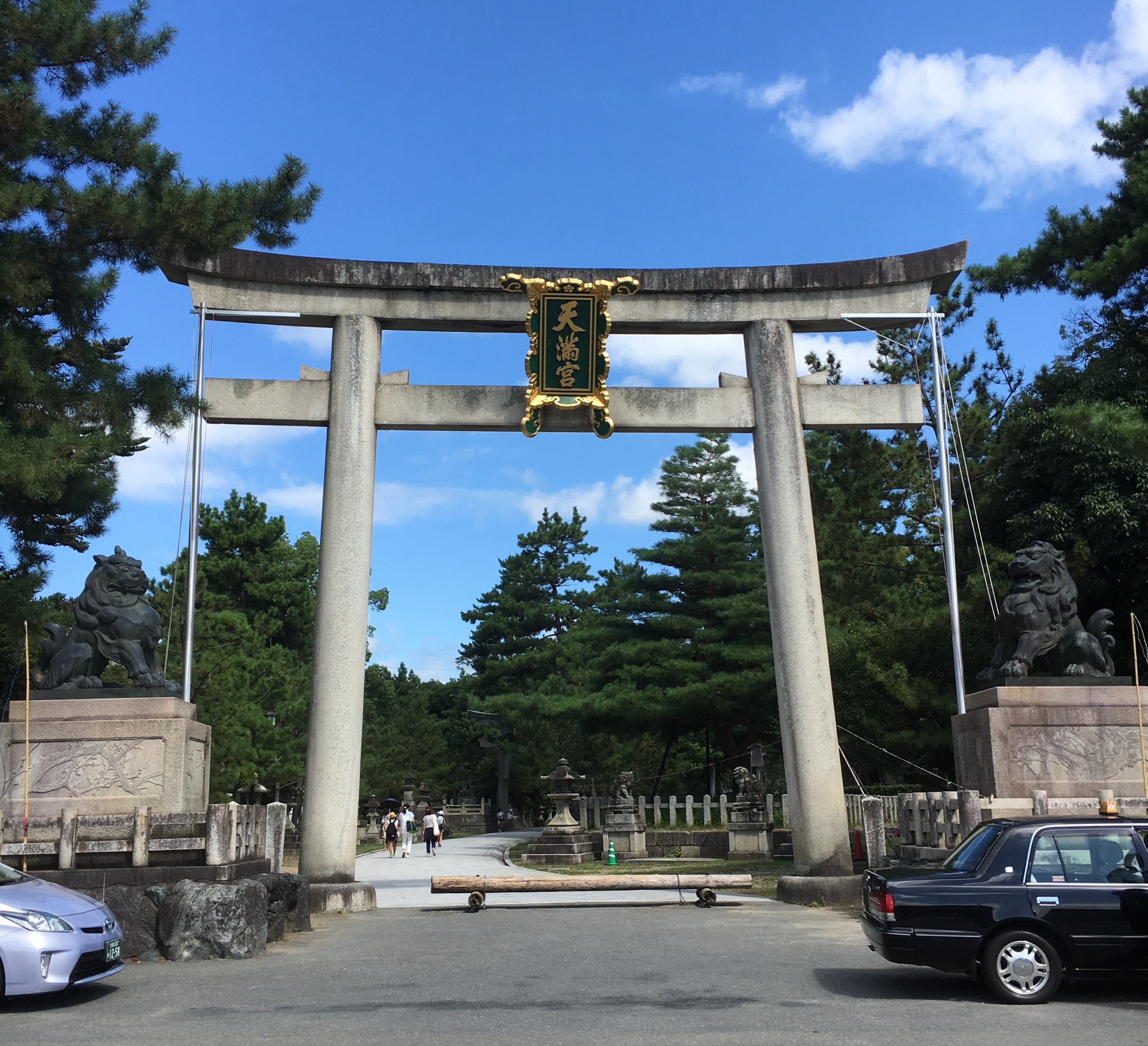 large torii of kitano tenmangu shrine and cars in front 