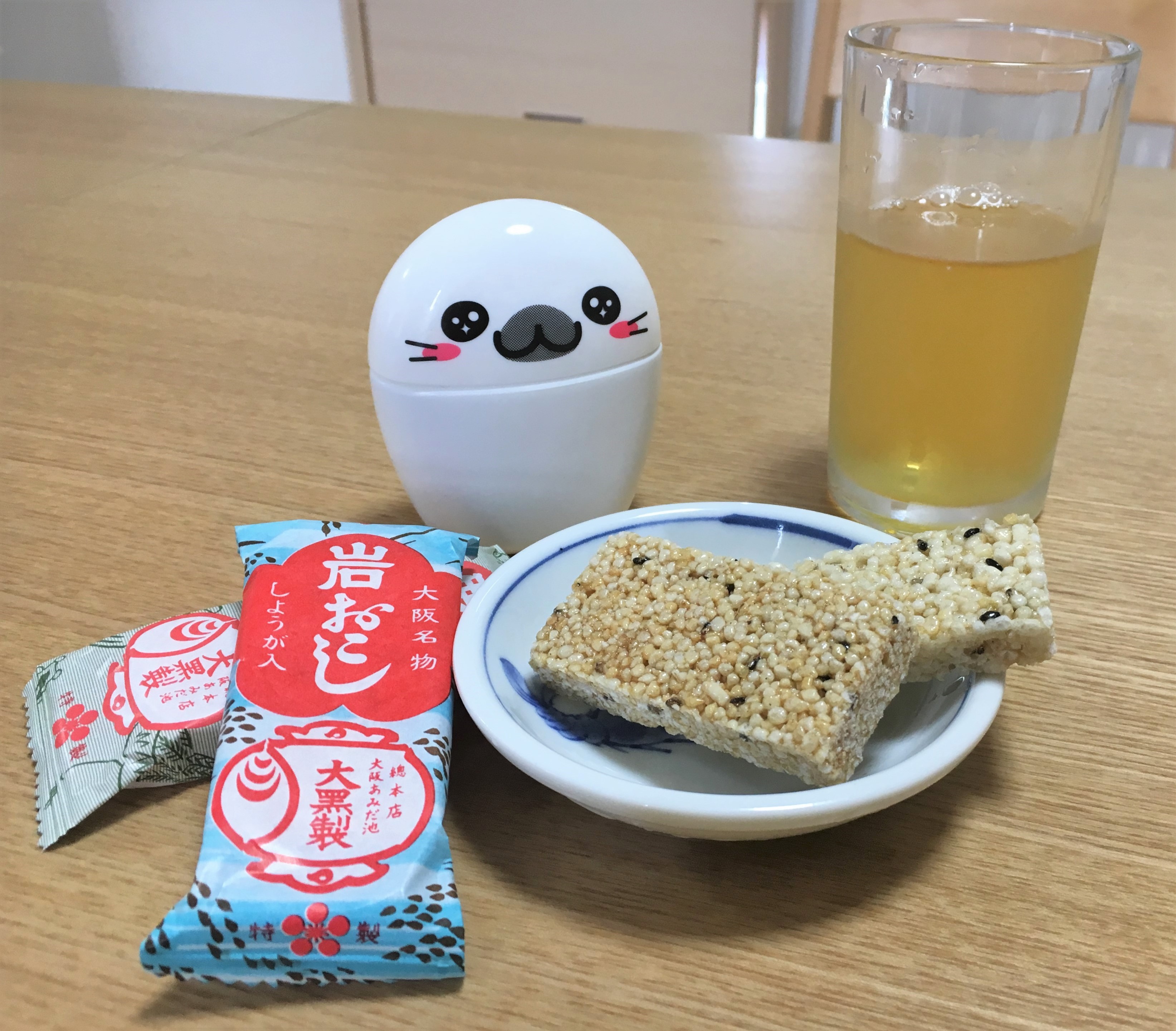 Daikuku's iwa-okoshi and awa-okoshi on a wooden table with a glass of cold tea