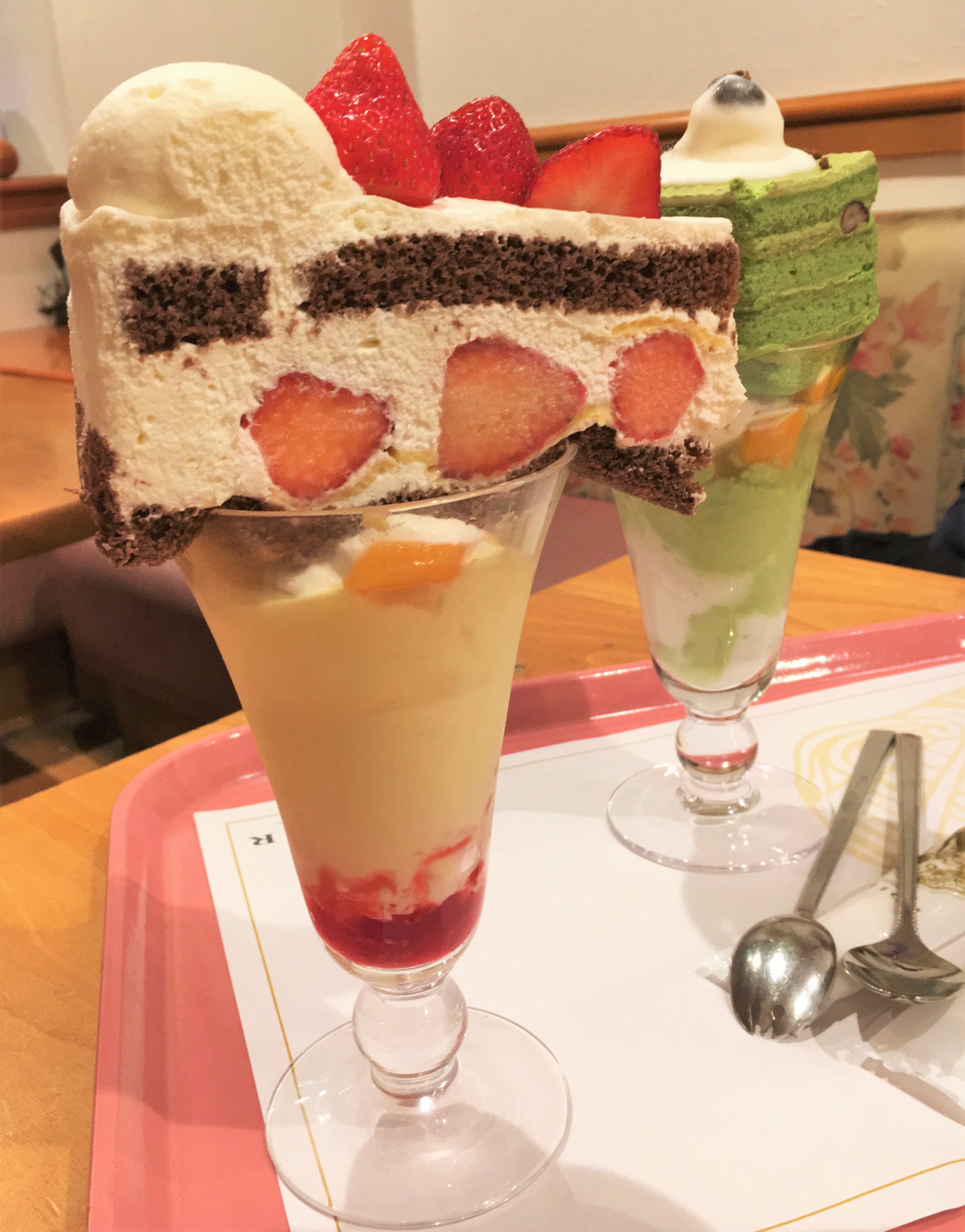 Mior cafe parfait a slice of chocolate and strawberry whipped cream shortcake on top of an ice cream fruit parfait 