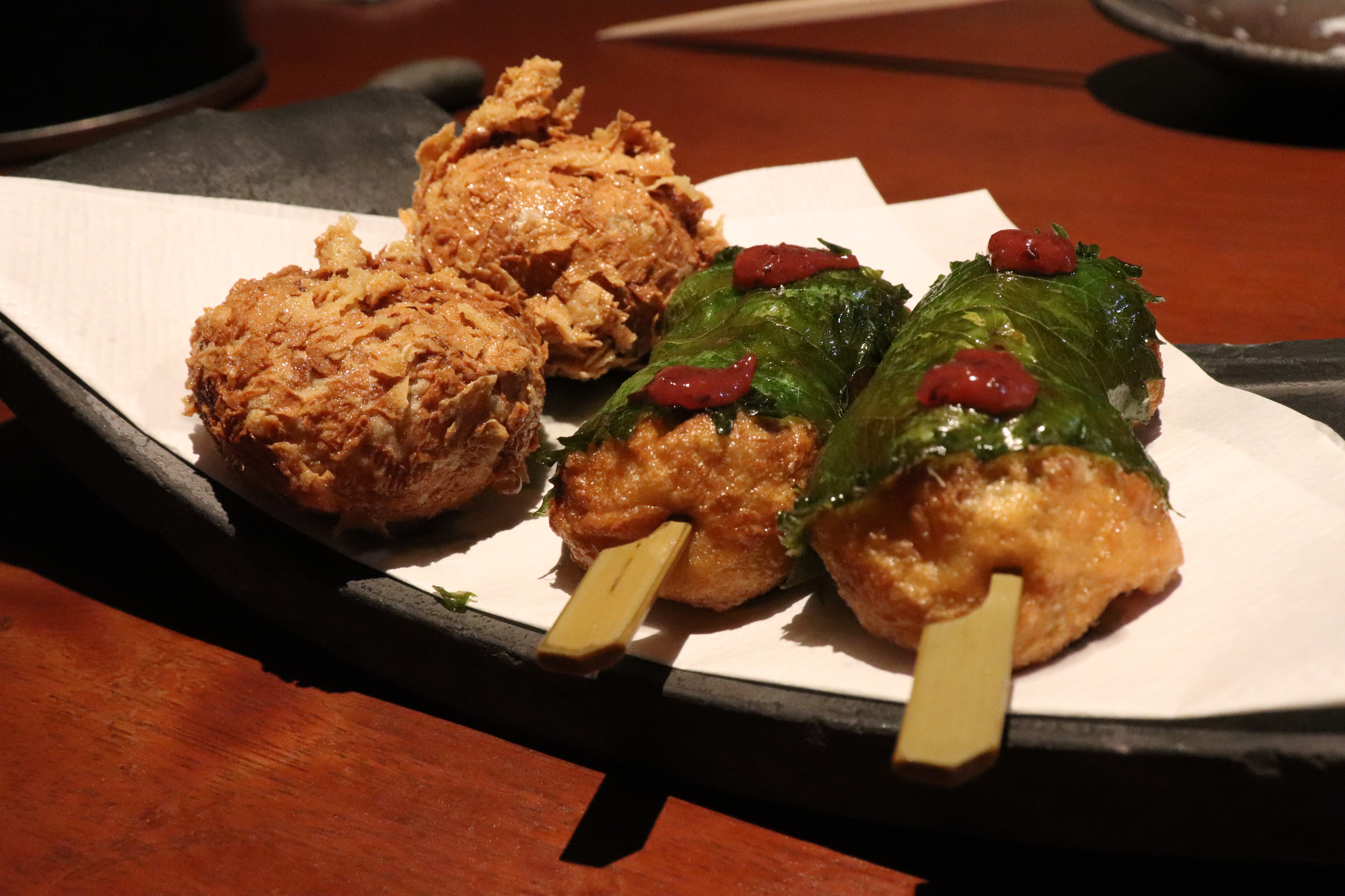 fried takoyaki, two rolled in tofu skins and two in shiso