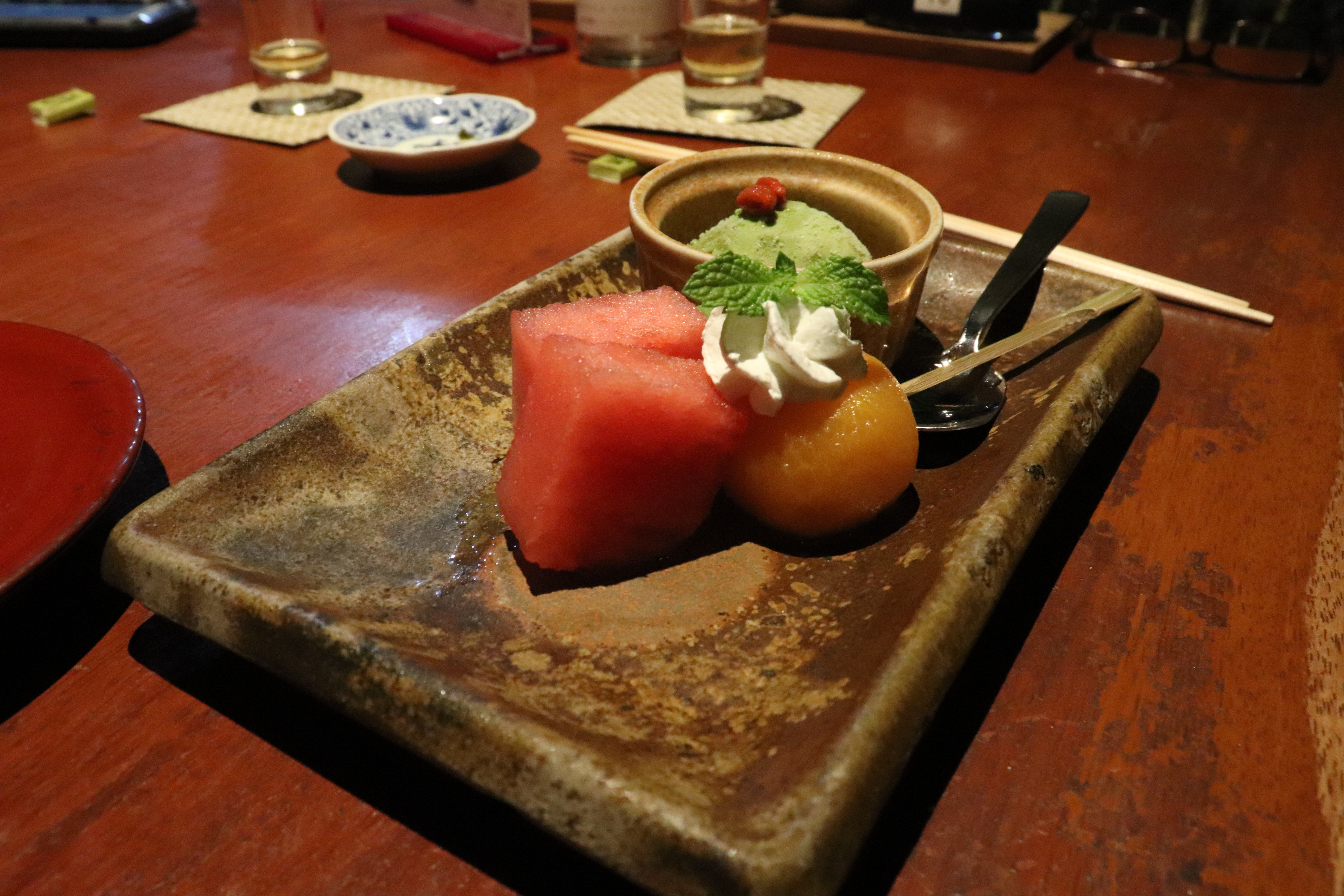 desert of fresh fruit and a scoop of green tea ice cream topped with two goji berries at takomasa chikusui-tei