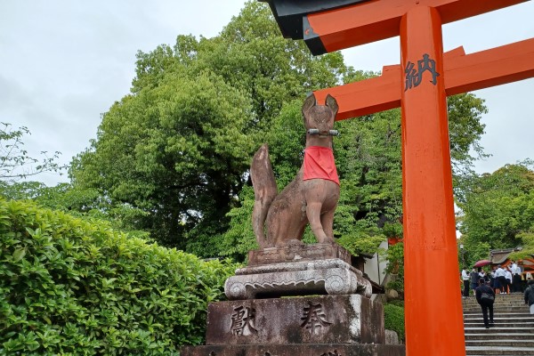 Statue of fox with a scroll in its mouth at Fushimi Inari Taisha