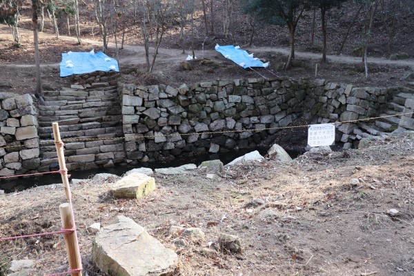 Stone walls around an empty pond at Bicchu Matsuyama Castle