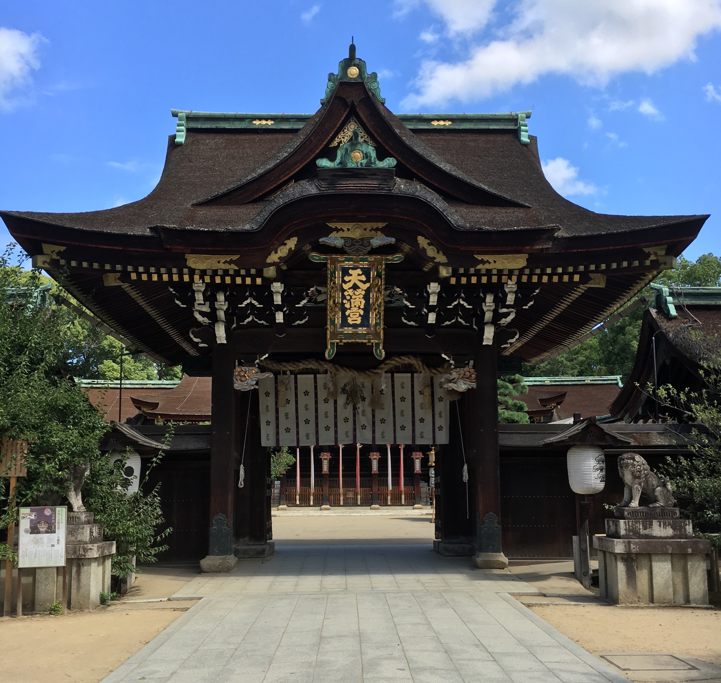 iconic gate at kitano tenmangu shrine with large name plate in gold lettering