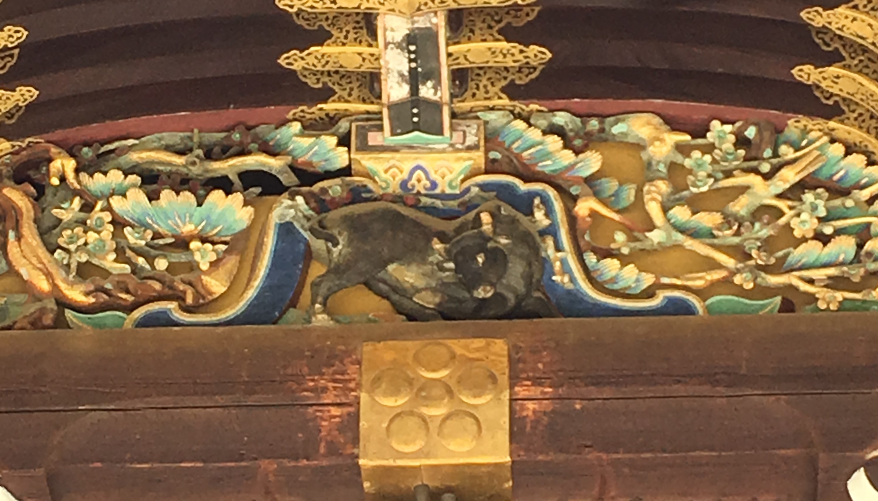 elaborate carving of a black cow above a shinto shrine 