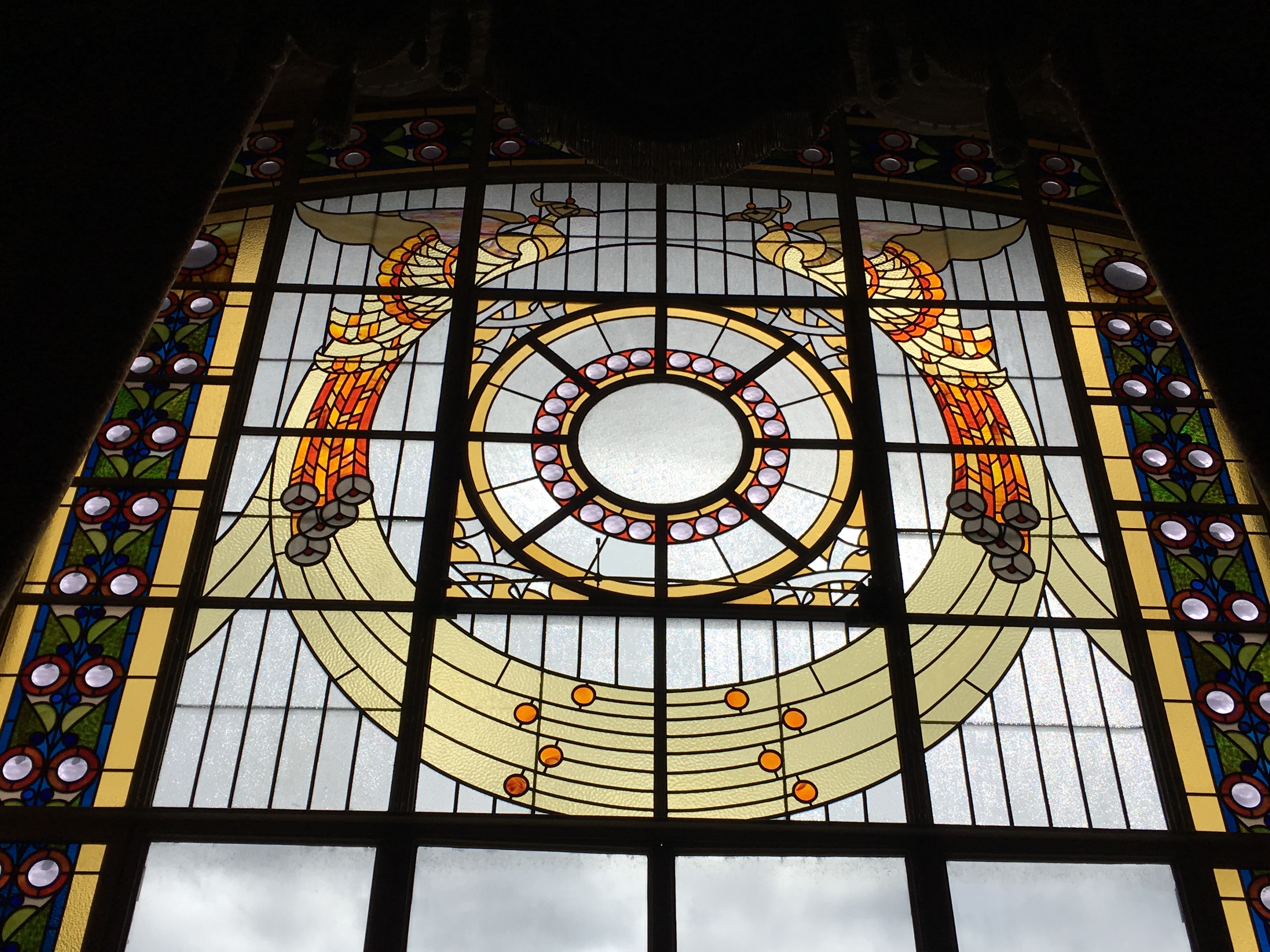 large stained glass window with two golden phoenixes 