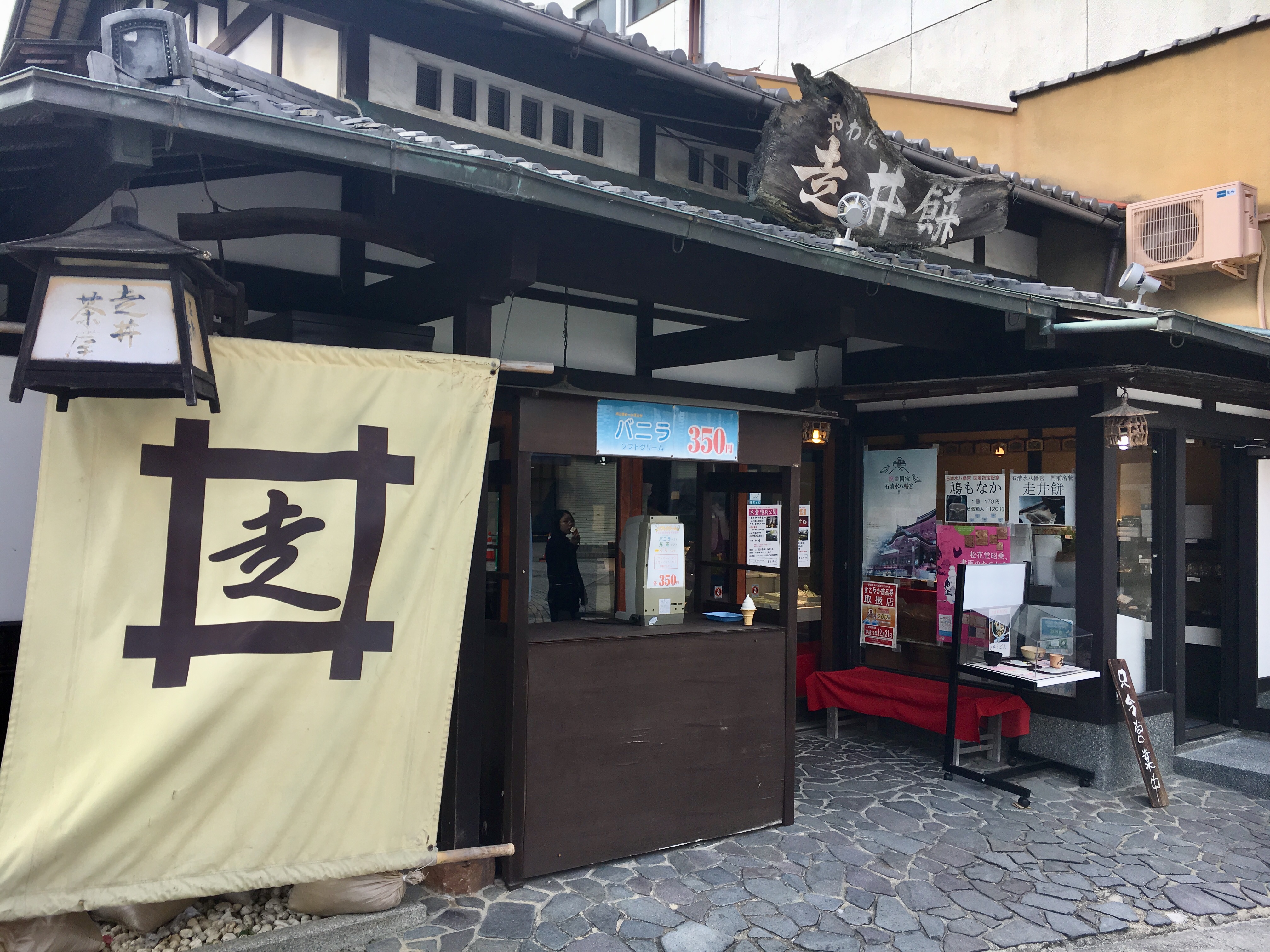 old fashioned Japanese restaurant with dark wood fixtures and large cloth sign 