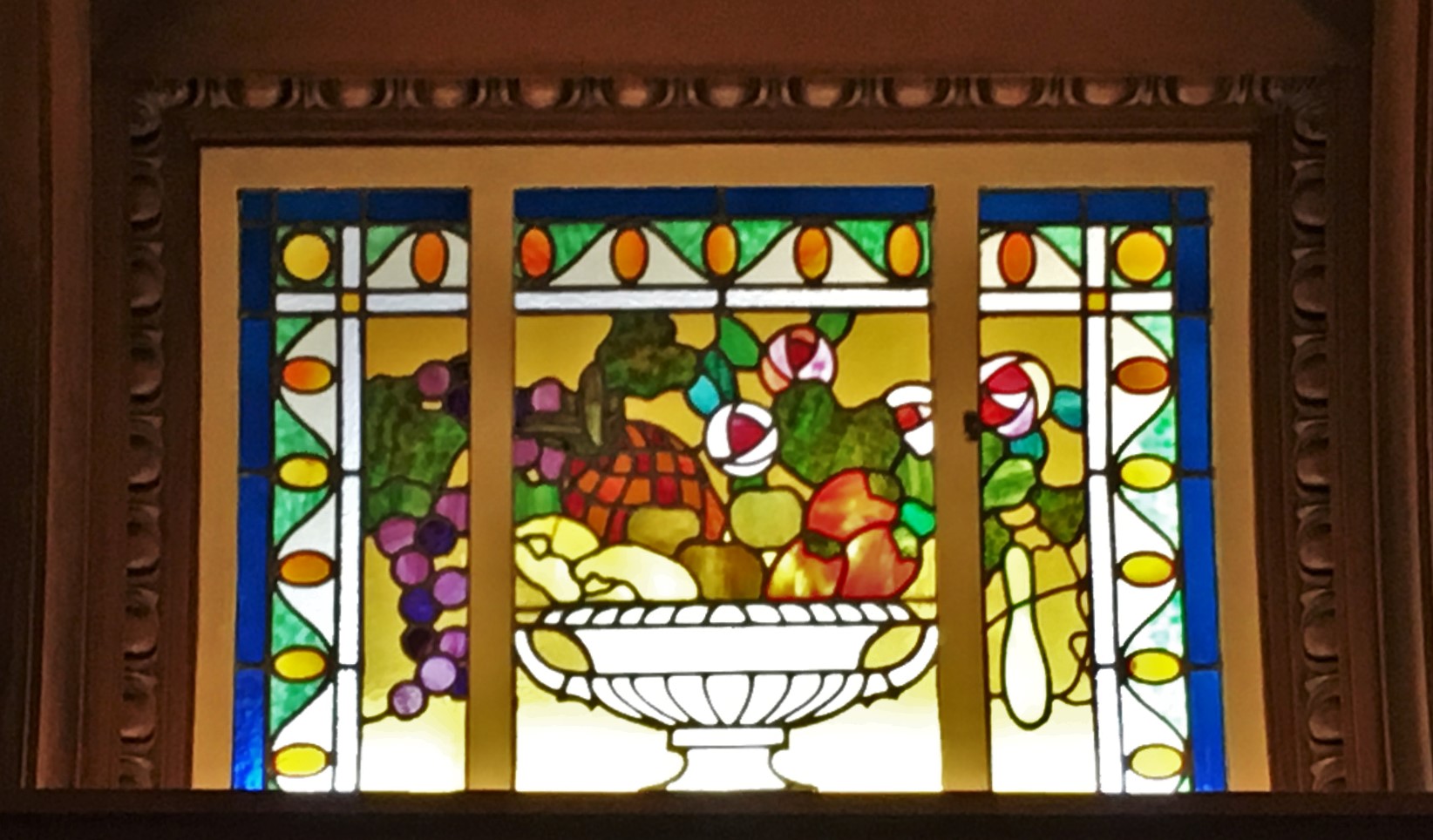 stained glass pane of a bowl of fruit warm backlight