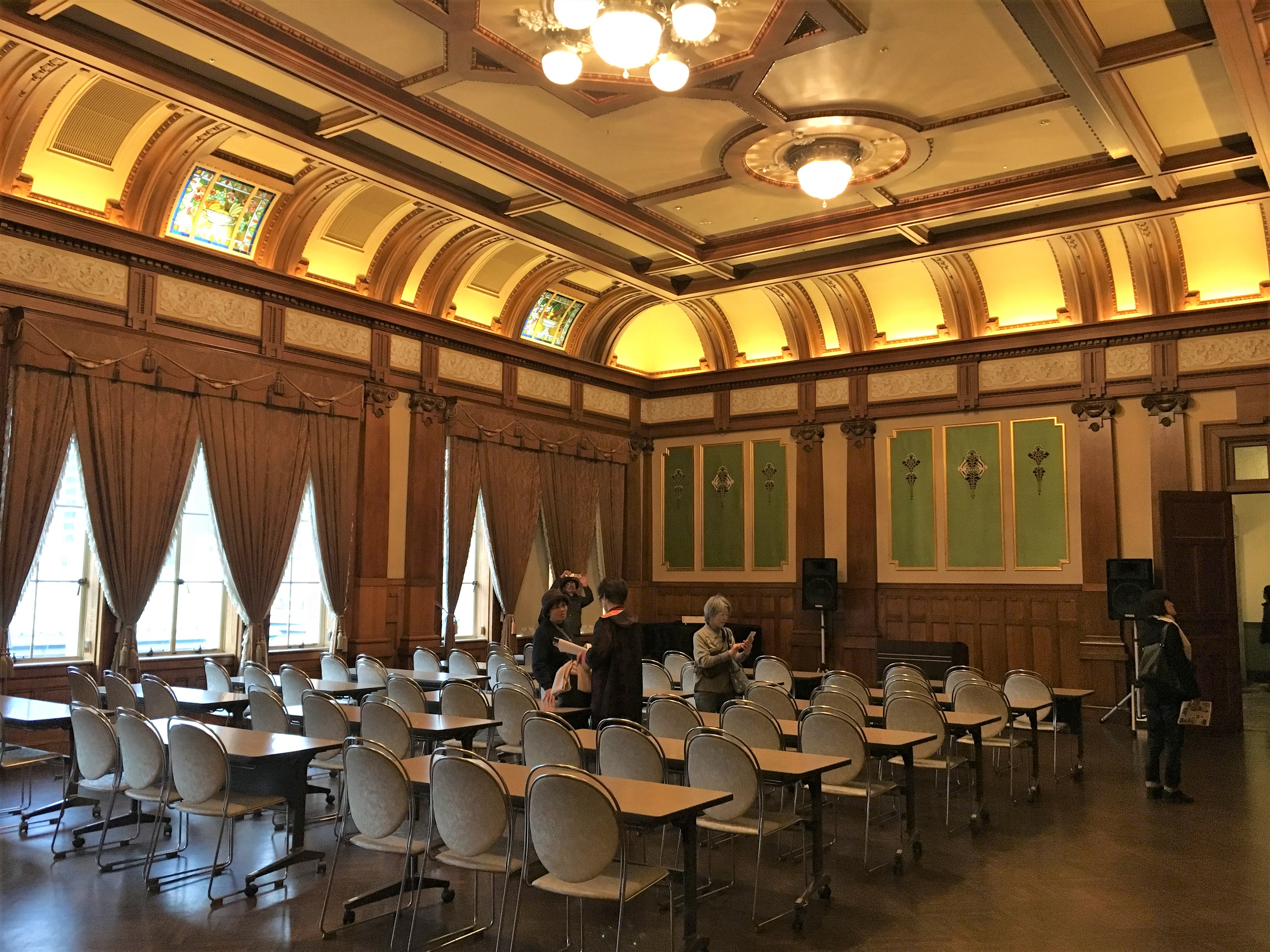 green and gold neo-classic lecture room with wood details