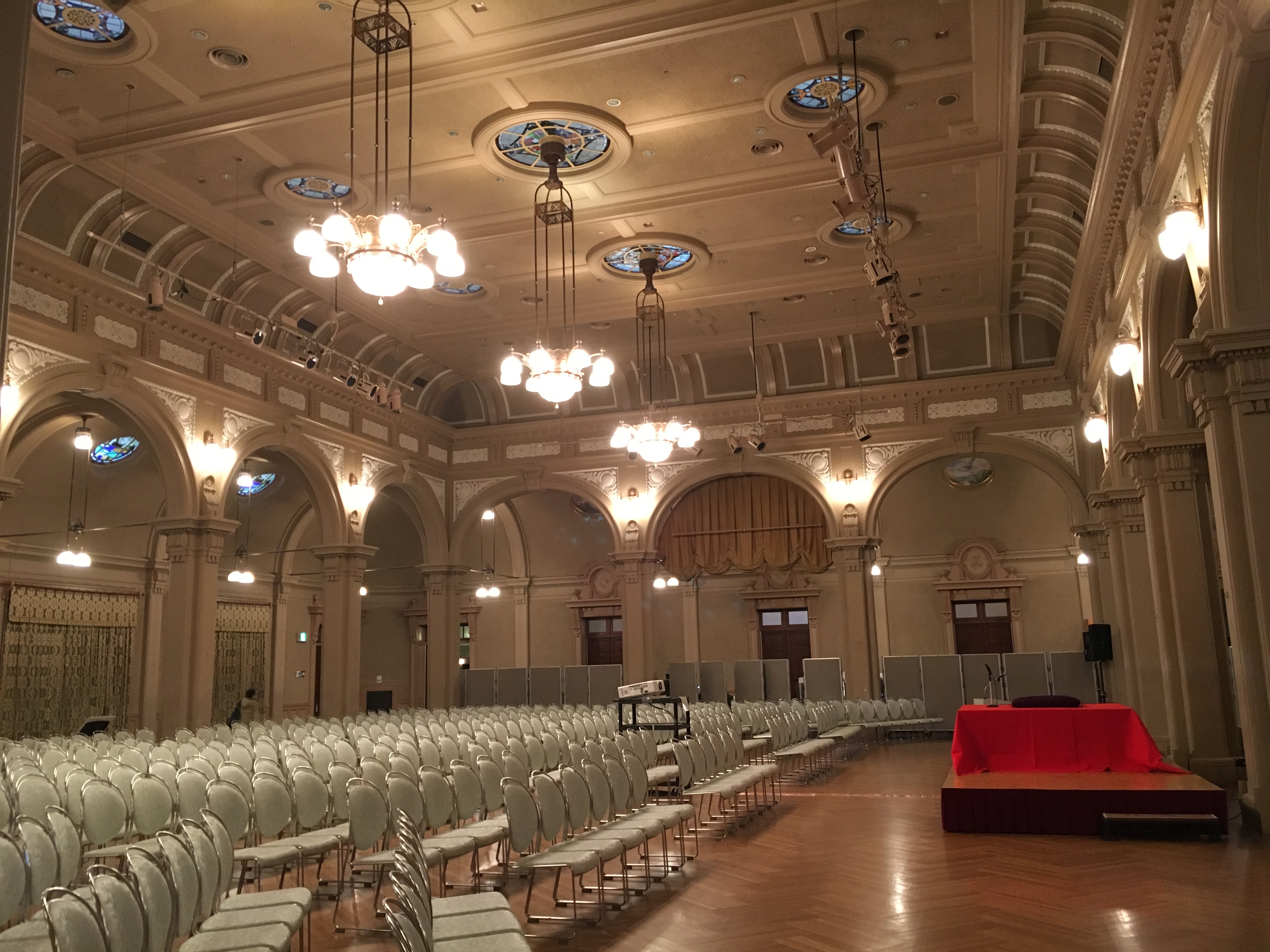 neo-classic ceremony hall at Osaka City Central Public Hall with crown moldings stained glass panes and chandeliers 