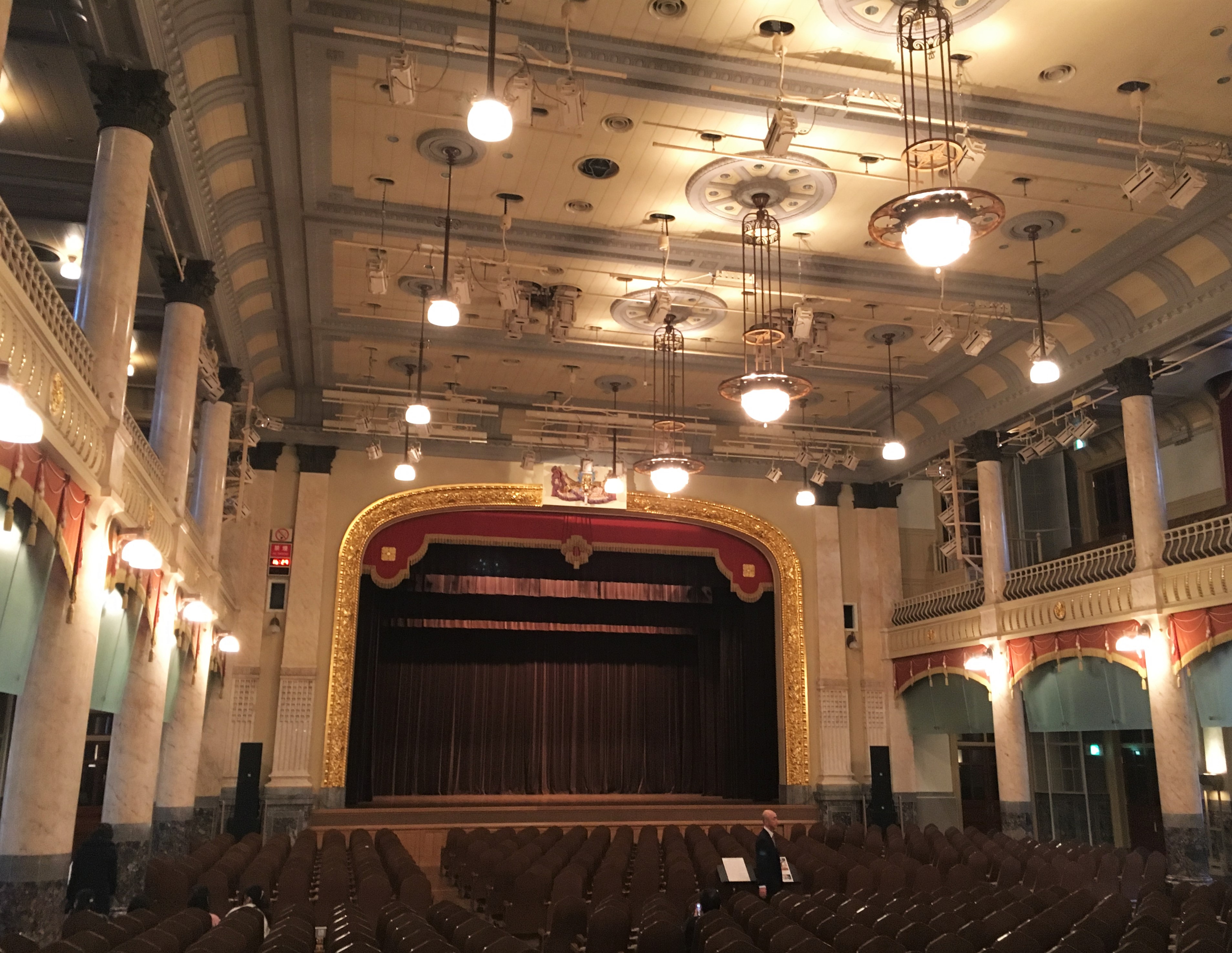 auditorium hall with marble pillars golden fixtures and chandeliers 