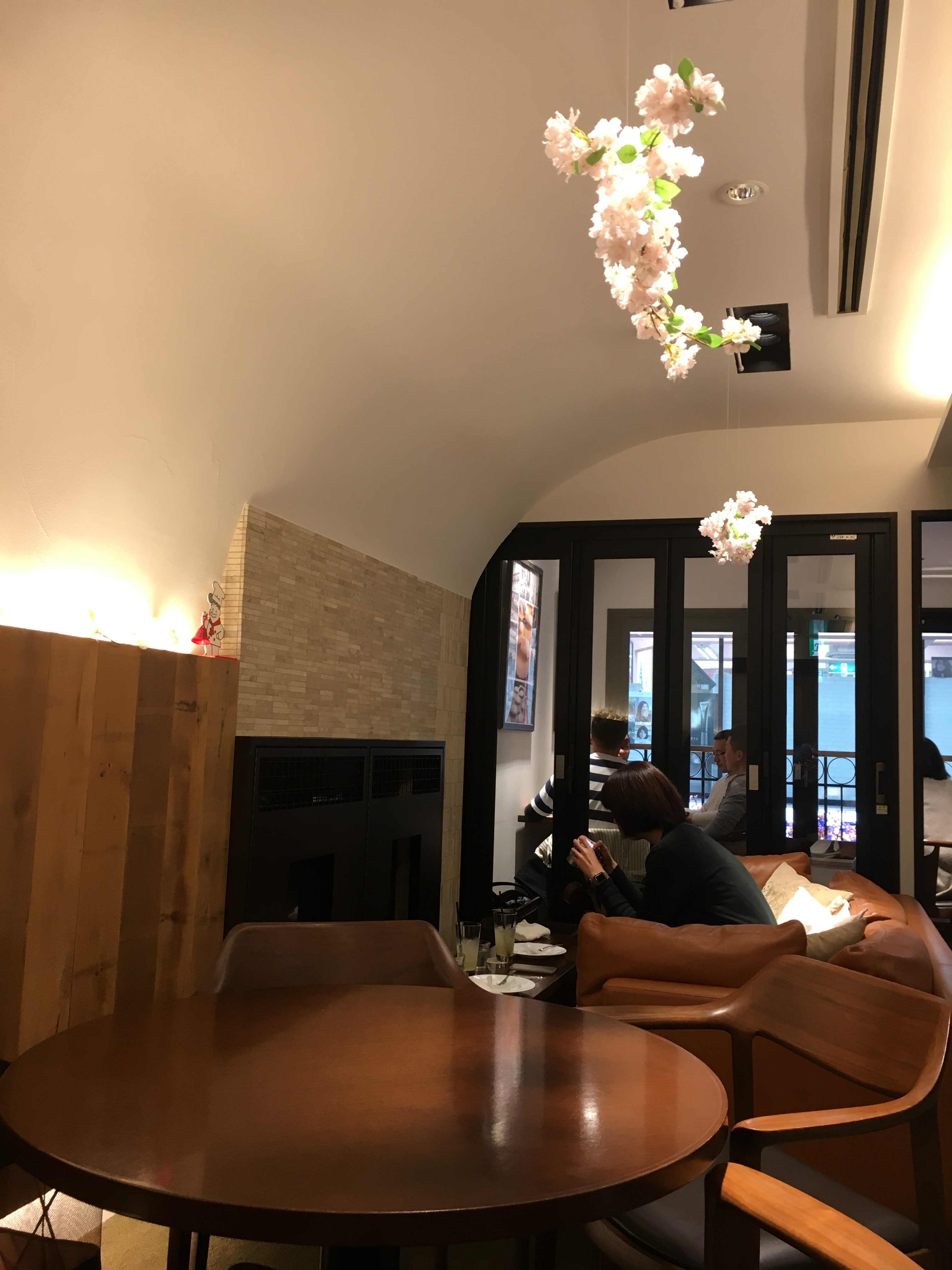 warmly lit cafe with wooden accents and fake flowers