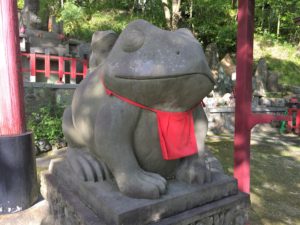 statue of a frog with a red bib