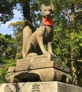 stone statue of a fox holding a key in its mouth