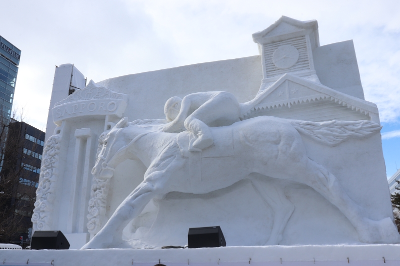 Snow statue of a thoroughbred and clock tower 